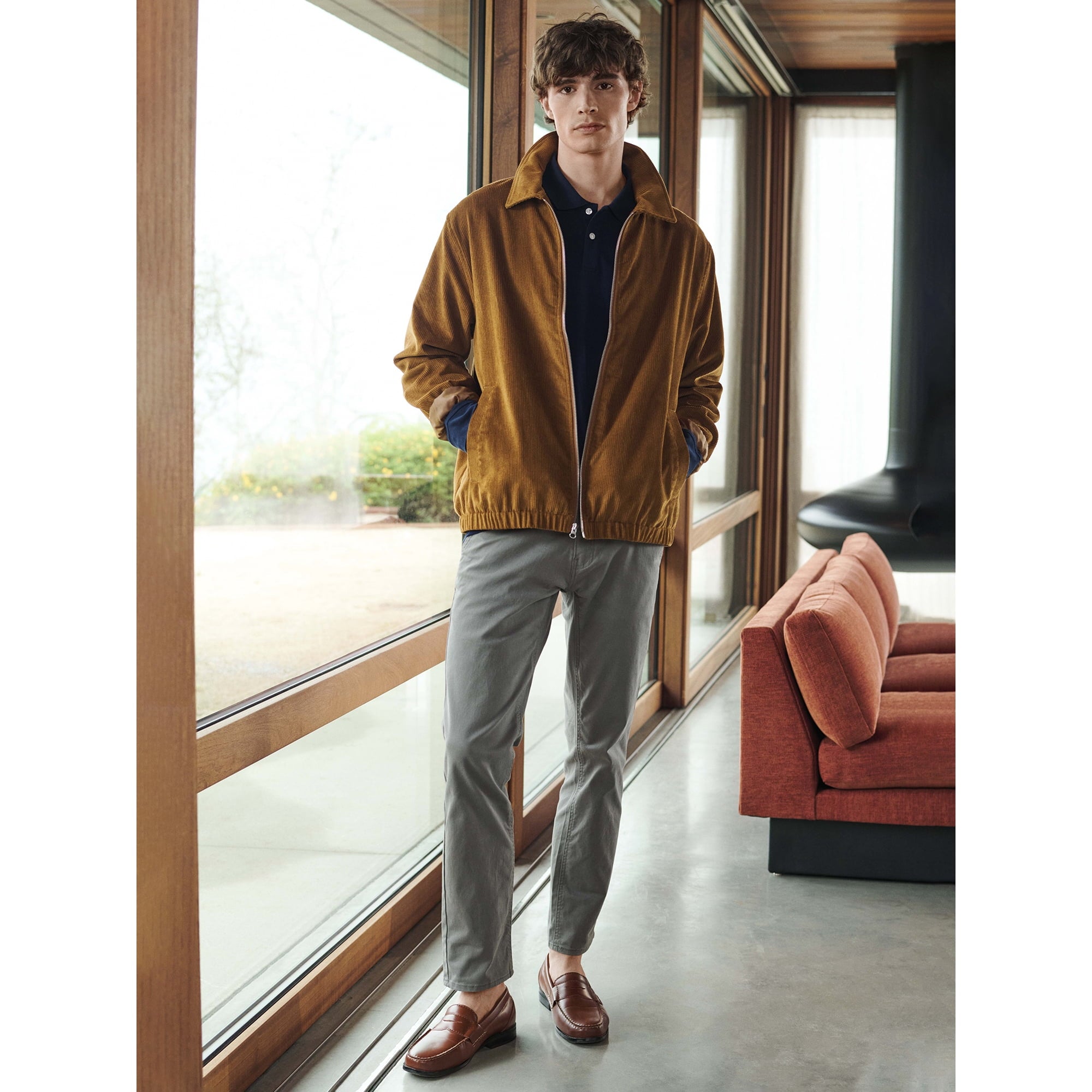 Man wearing a mustard jacket in a modern living room.