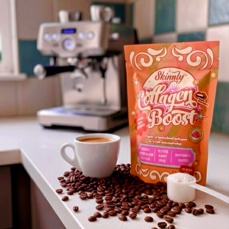Skinnly Collagen Boost package with a cup of coffee and coffee beans on a kitchen counter.
